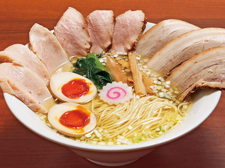「青森シャモロック塩鶏中華そば(特製3種肉盛り・味玉付き)」(1,100円)。青森シャモロックの丸鶏スープと5種類の貝出汁の香りは極上。シンプルながら旨みがあふれる一杯だ。3種チャーシューの贅沢感もうれしい