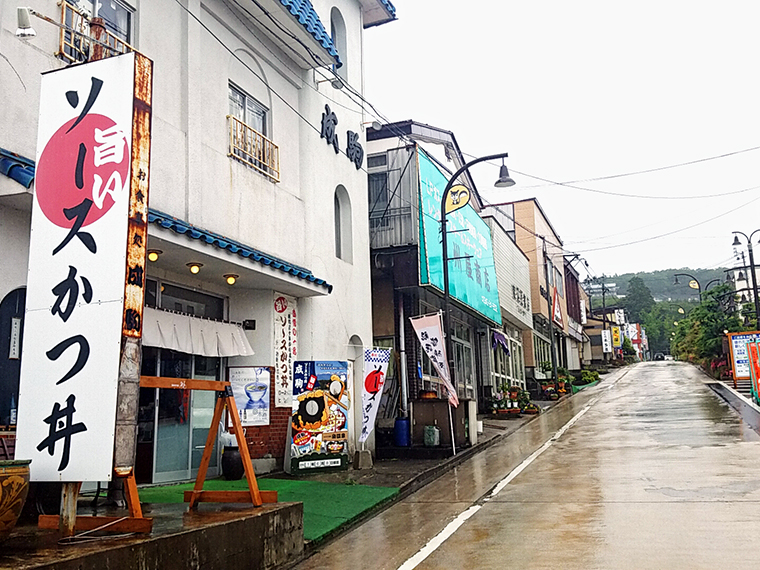 雨の岳温泉街に映える「ソースかつ丼」の看板