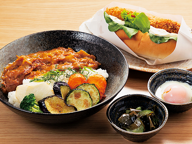 「和来亭西郷館」で人気の「和来カレー」(800円)。旬野菜の素揚げと、温玉が付く。7種の地場野菜を使用したコロッケが挟まれた「にしごういいねドッグ」(400円、スープ付き)と一緒にぜひ
