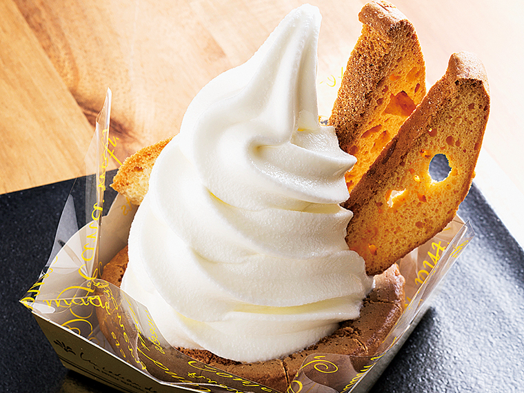 甘食を逆さにしたカップに牛乳ソフトを載せた名物「甘食ソフト」(495円)。ビスコッティのような甘食ラスクでソフトクリームをすくって食べても