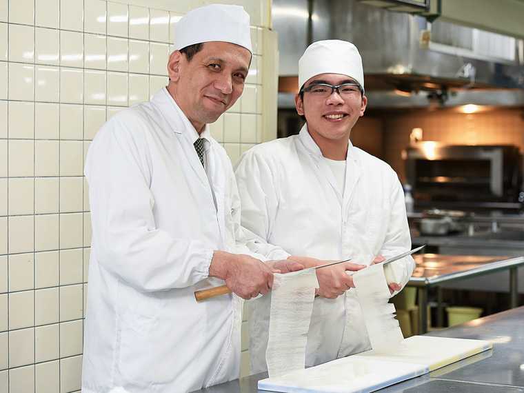 料理長の元宗邦弘さんと入社1年目の田中基貴さん。職場は和気あいあいとした雰囲気