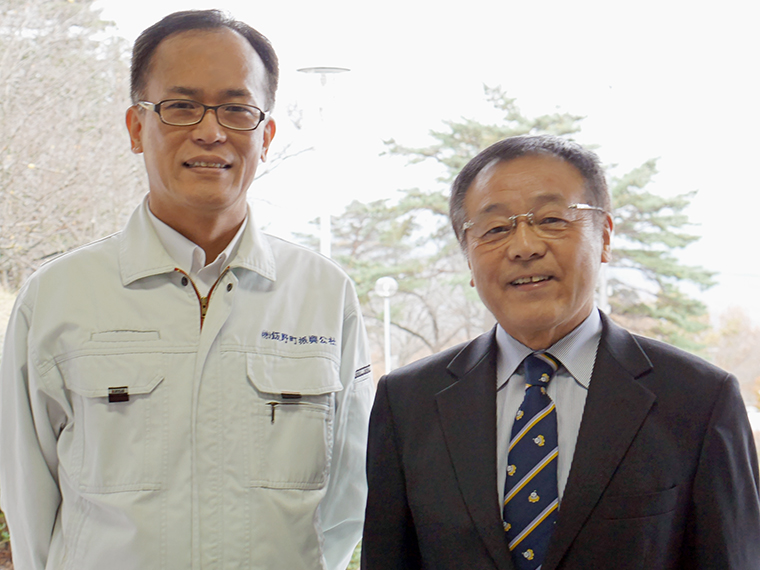 事務局長の菅野利男さん(右)と職員の菊田清司さん。事務局長が身につけている『ゆーたんネクタイ』(3.300 円)は物産館で絶賛販売中