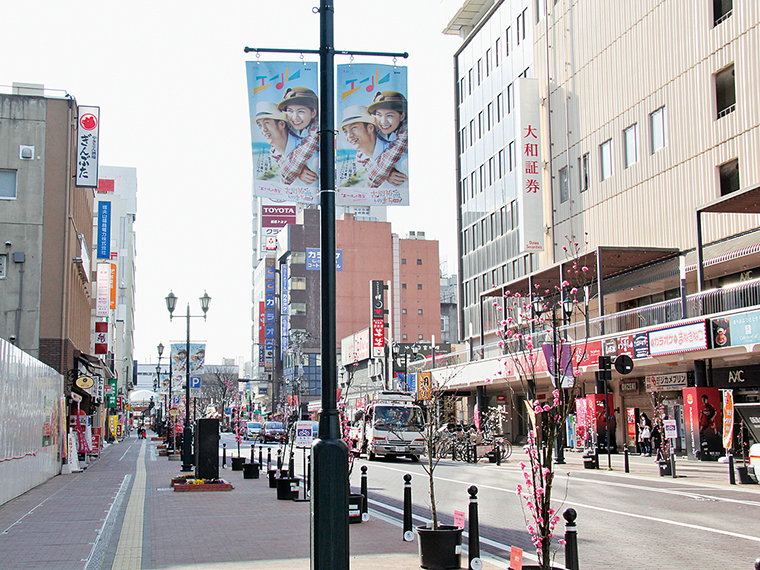 現在の駅前通り。柳並木はありませんが、エールのフラッグを掲げた街灯が並んでいます