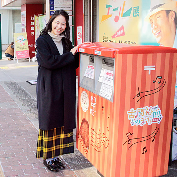 投函後にポストと撮影する井上さん。笑顔がキュート!