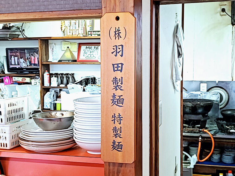 壁に掛けられた「(株)羽田製麺 特製麺」はこだわりの証