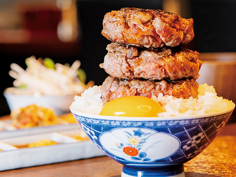 焼いたハンバーグをご飯にのせ、タレをたっぷり！こんな贅沢な食べ方も思うまま。トリュフ卵黄も絡めて、口の中へ！「国産牛100%の粗挽き赤身ハンバーグ」はご飯、スープ、小鉢が付いて1,500円。肉は両面をサッと焼いて、レアで食べるのがおすすめ