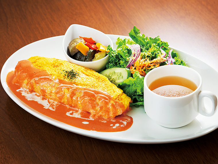 スープ、サラダ、小鉢が付く「たっぷりシーフードのjuju風オムライス」（1,080円）。ソースは、ホワイトソースも選べる