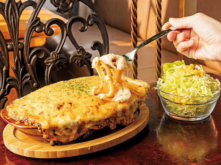 「スパゲッティグラタン（サラダ付き）」（1,100円）。写真はミート味。ミートソーススパゲッティの上にホワイトソースと3種類のチーズを乗せてこんがり焼き上げた熱々が絶品