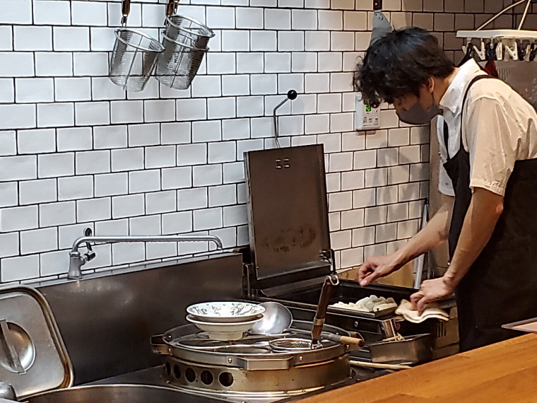 あみだくじしたくなるほど美しい厨房で、餃子を焼く店主の姿も美しい