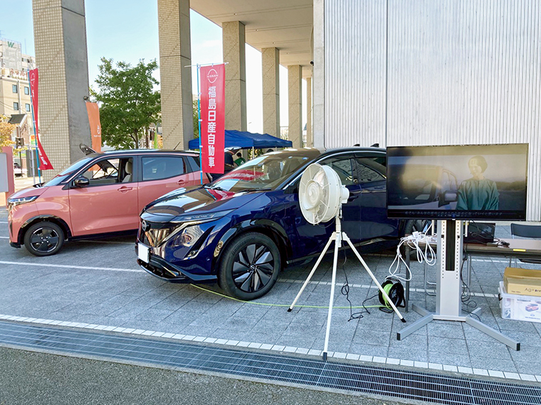 電気自動車のアリアとサクラを蓄電池とし、給電をしている様子