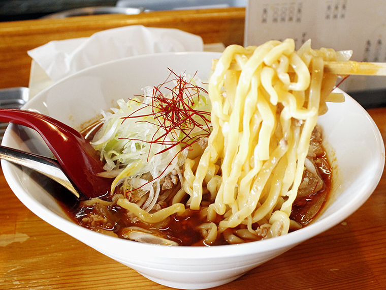 丸鶏と魚介の風味が香る絶妙なスープに、極太の手揉みちぢれ麺が絡む。ゴロっとしたひき肉とタマネギの食感も楽しい。他の担々麺とは異なる『郡山たんたん麺』だけのオリジナル