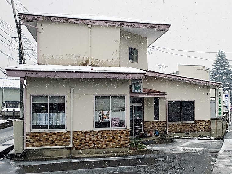 住宅のような佇まいのまるみ食堂さん。白地にグリーンの看板が味わい深いです