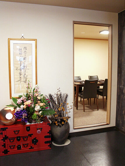 8名までゆったりと使える奥の個室。入口には吉幾三氏の書や花が飾られ、和の上質感を演出
