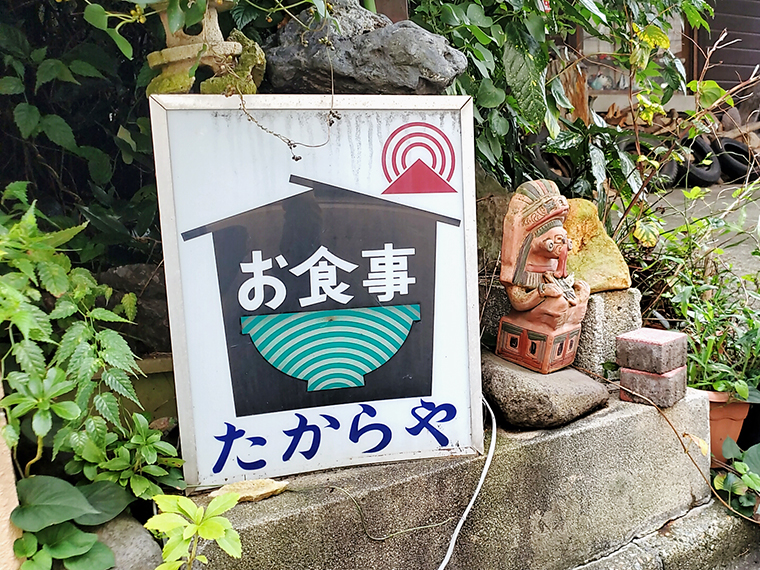 店先の足元には、趣のある看板と神様が