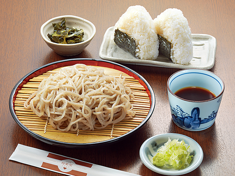 「冷ざるそば」(790円)とおにぎり(各150円)。北海道産利尻昆布と焙煎された鰹の厚削りを使用した特製ざるつゆに十割そばが絶妙に合う。おにぎりは昆布、鮭、おかかの3種類。テイクアウトもOK。他に肉じゃがやきんぴらなどの総菜も