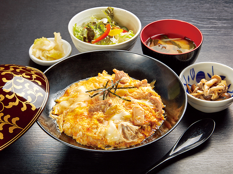 「ぜいたく親子丼」（1,350円）。濃厚な味わいの本宮烏骨鶏の卵、噛むほどにうまみが出る会津地鶏の肉、コク深いダシが相性抜群。とろ〜り半熟に仕上げた卵の食感がたまらない。みそ汁、サラダ、小鉢、漬物が付く