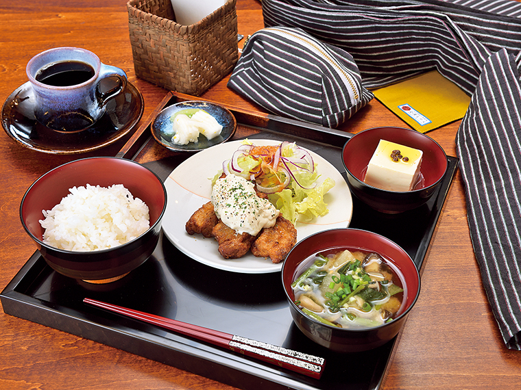 「つきない会津のめぐみ 車麩のカツ南蛮定食」（1,500円）と「けんぱくブレンド水出し珈琲」（500円）。オリジナル商品（奥）も販売