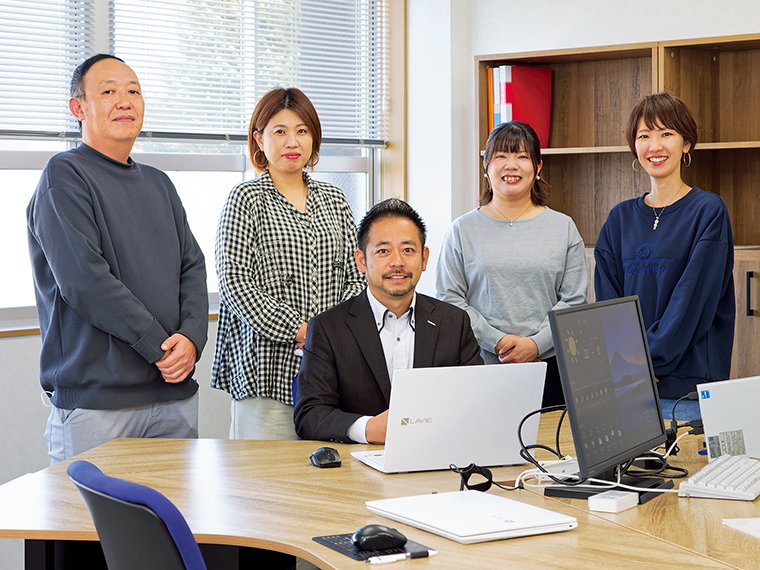 開設したばかりのオフィス「アイナスプランニング」でスタッフの皆さんと。右端が奥様の亜由美さん