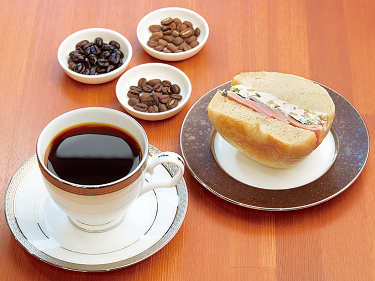 「深煎りコーヒー」(500円)と「プレーンベーグル・ネギ&いぶりがっこチーズ」(450円)。一番人気のベーグルサンド。毎日数種類が並ぶ。無薬飼育した卵を使ったエッグピクルスをサンドしたものもある