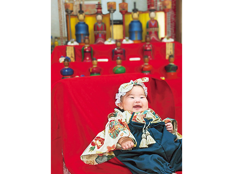 「赤ちゃん温泉デビュープラン」は、晴れ着の無料貸し出しがある。ロビーに飾られたこけし雛の前で笑顔で記念撮影