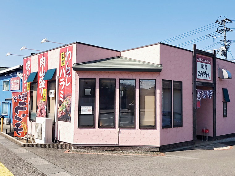 ピンクの外観と、相撲の懸賞幕のように掲げられた名物メニュー