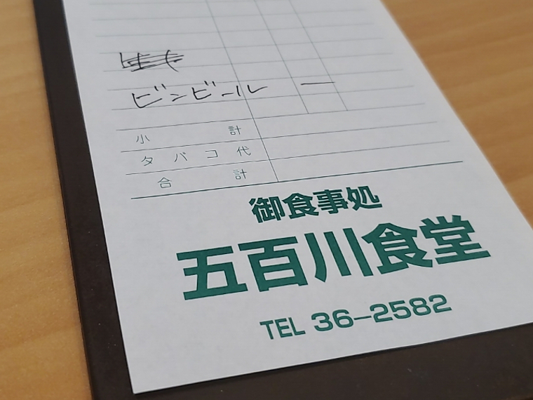 白に緑のフォントが映える伝票を携えてレジへ