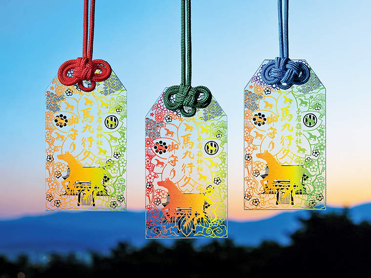 虹色に輝くスケルトンの新お守り。中央に印されている「馬九行久」は「うまくいく」という縁起の良い言葉