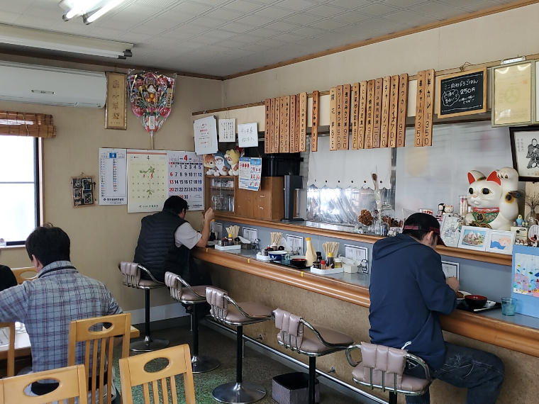 ビニールカーテン越しに厨房の活気を感じる店内