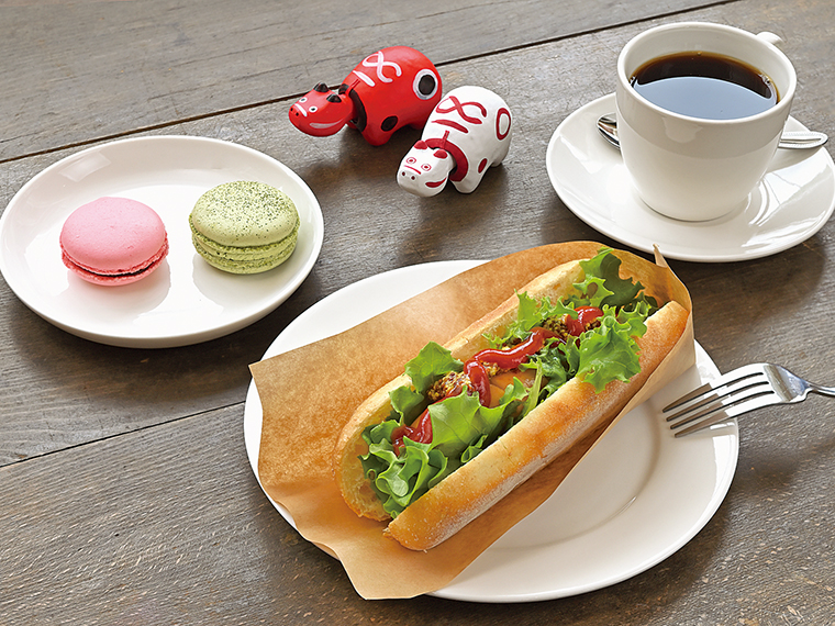 ランチタイムに提供する「ホットドッグ」(550円)、「あいべこブレンド珈琲」(500円)。「パティスリー塔之坊(とうのぼう)」が作るマカロンは1個350円
