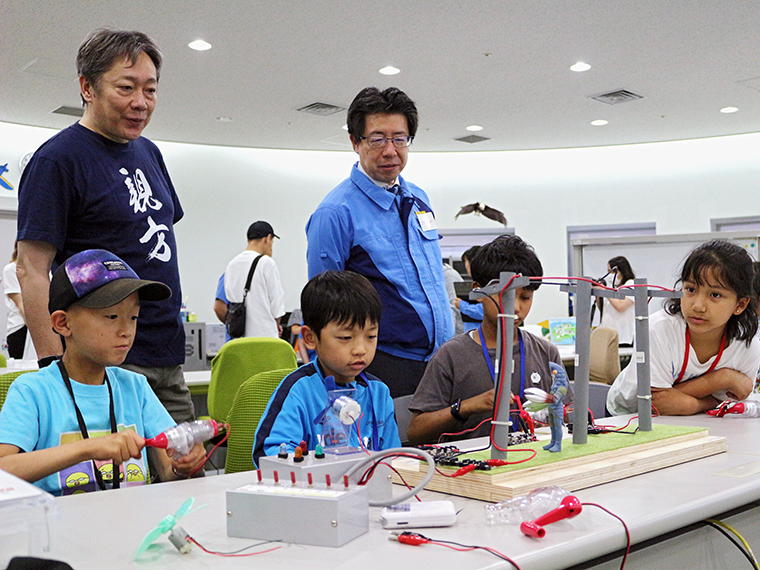 チームになって、電気を作ります。発電した電気が光や音、動力に変わることを学びました