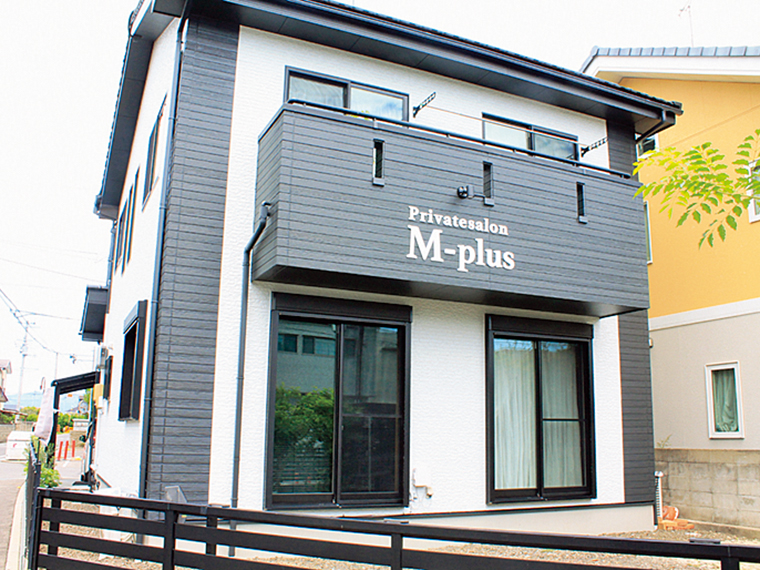 自宅兼サロン。黒地に白で書かれた店名の看板が目印