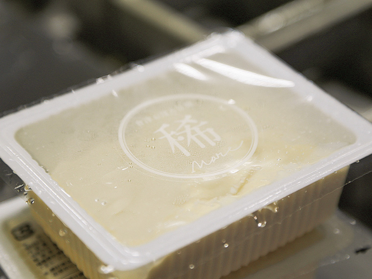 「會津おぼろ豆腐［稀］」（200円）。「おぼろ」という言葉のイメージを「1℃、1ml」にこだわって表現した豆腐。すり潰した大豆（呉）を煮る時間、蒸気の強さ、香りチェックが一番のポイント。まずは何も付けずそのまま味わって、その後はわさび醤油を少し付けて食べてみよう