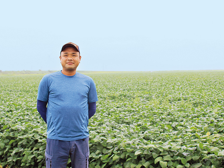 生産者の櫻井義晴さん。大豆の生産を始めて約20年。機械を用いながら少人数で畑を管理している