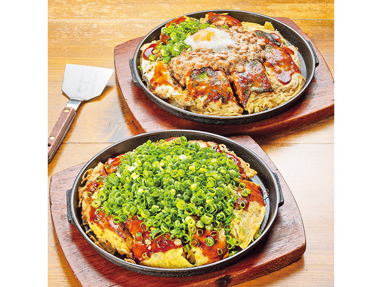 手前から「カガちゃんスペシャル」（2,150円）と、納豆と温泉卵を乗せたお好み焼き「福島スペシャル」（1,980円）