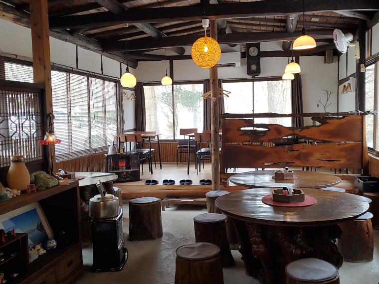 中央に木桶の蓋のような円卓。一段上がるとテーブル席