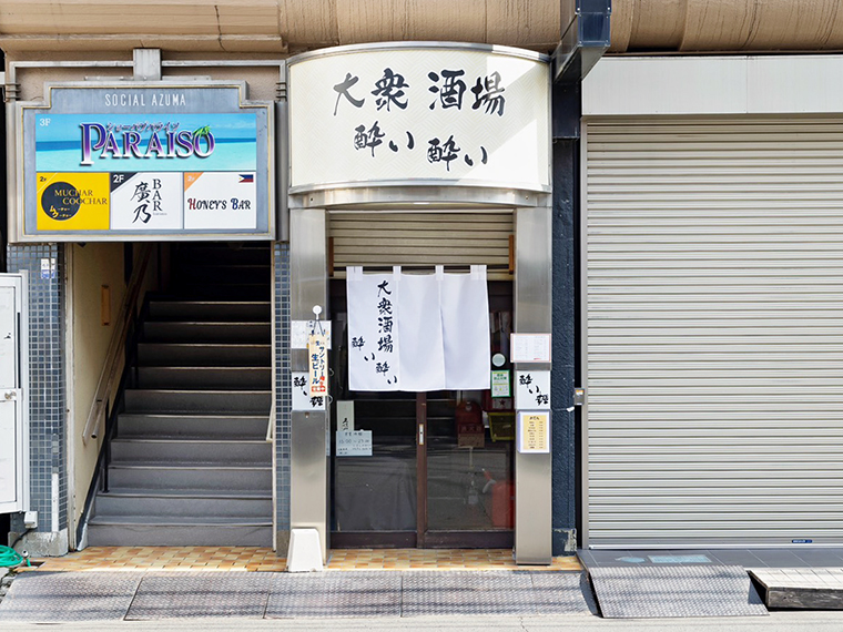 「国際パーキング」向かいにある白い看板とのれんが目印