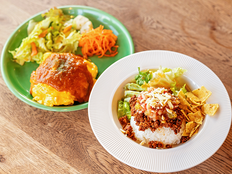 ランチセットの「オムライス（左）」と「タコライス（右）」（各1,200円）。全てのランチにスープ・サラダ・ドリンク・デザートまで付いて大満足。プラス100円でコーヒー付き、プラス150円でテイクアウトコーヒー付きにもできる。メニューは日替わりなので店内の黒板をチェックしてみて