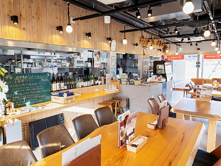 木の温もりあふれる店内。カウンターにはワインのボトルが並んでおり、夜は地元のお酒が楽しめます
