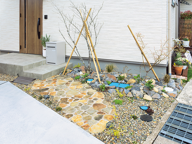 大小の自然石を敷き詰めた延段のある庭。趣ある延段のアプローチから植物の成長を楽しめる