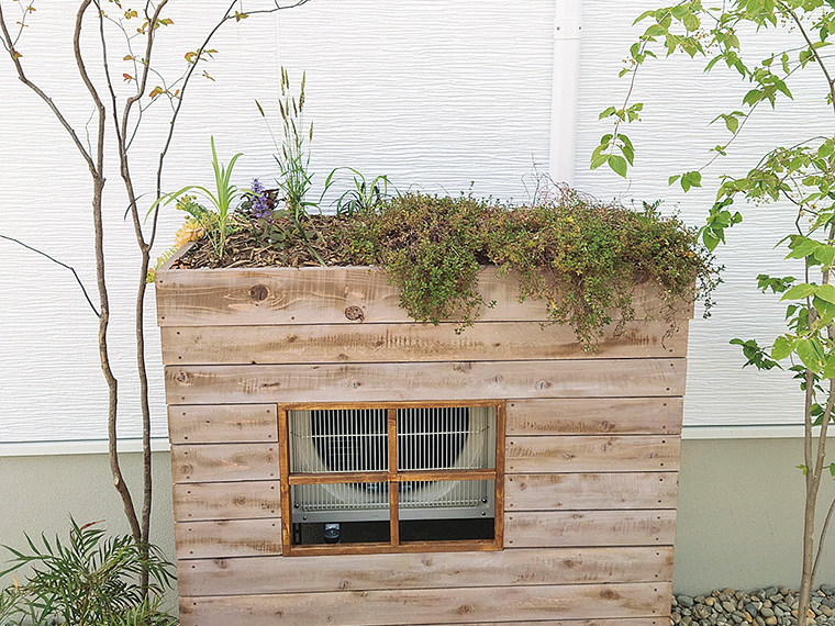 生活感が出てしまうエアコンの室外機の上に、かわいらしい草屋根を配した。無機質な機械を隠すだけでなく、庭の一部として溶け込ませるアイデアが光る