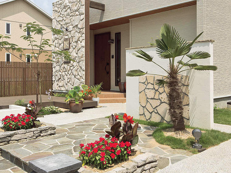 石張りのアプローチ周辺にシュロの木を植えて、南国の旅先のようなリラックスムードを演出