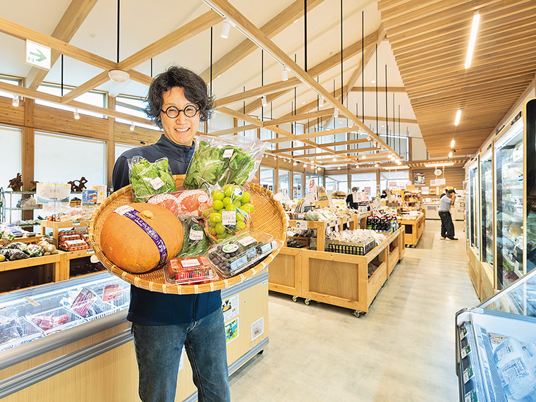 笑顔でお客さんを迎えるスタッフの渡辺さん。店内には、日本野菜ソムリエ資格を持つスタッフが厳選した旬の食材が多く並ぶ
